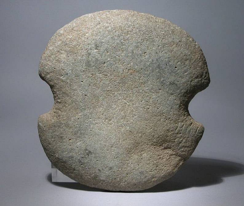 Dominican Republic, Pre-Taino Stone Double-Bitted Axe
This type of large, worked stone double-bitted axe can be assigned to the "Courian Subseries," a classification designating the period that ended some time just after the Lithic Age and just before the Ceramic Age.  These large axe heads, used in combat, were strapped to a large staff with strips of leather.  A similar example is illustrated and discussed in Irving Rouse’s "The Tainos: Rise and Decline of the People Who Greeted Columbus,” Yale University Press, 1992, pg. 56, fig.16d.
With some natural wear.

Media: Stone
Dimensions: Width 7"
$2,250
94312