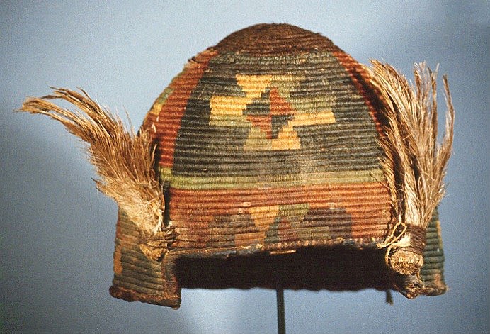 Chile, Pre-Inca helmet from Chile with Extended Cross Design
A coiled and reed cone shaped helmet and decorated with crosses within squares in alternating colors of blue and salmon with  a blue lower border.  A similar helmet is illustrated in IDENTITY AND PRESTIGE IN THE ANDES pg.44. The Andean civilizations never developed a piercing technology but utilized a clobbering warfare and needed insulated
Media: Textile
Dimensions: Height 11" Diam 9"
Price Upon Request
91131