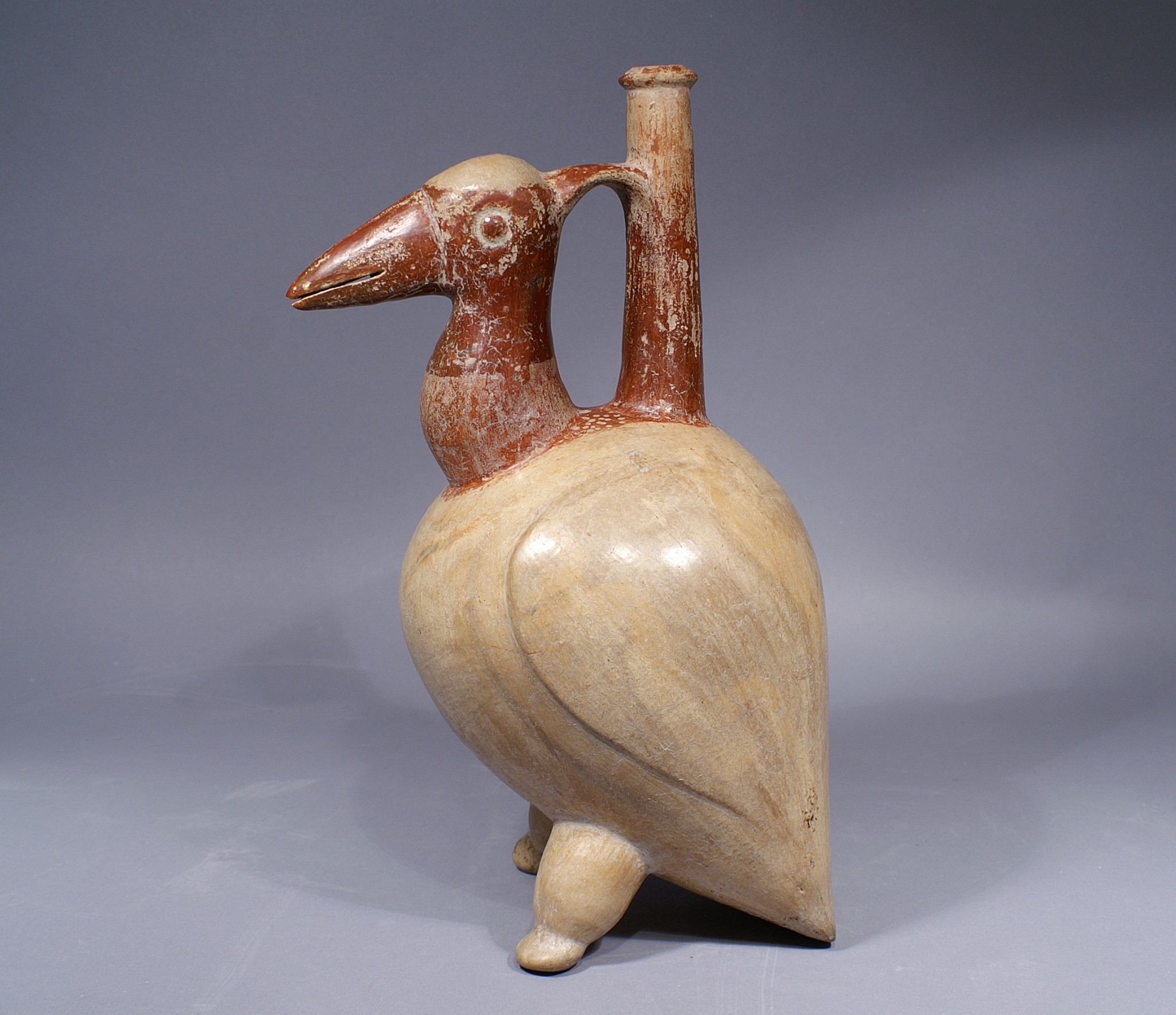 Ecuador, Chorrera Avian Effigy Spouted Vessel of a pelican
This effigy vessel represents a pelican decorated with red-brown slip on the head and neck over a buff body. The wings are softly modeled at the sides of the body, while the tail and quasi human feet support the vessel in a vertical position. Anthropomorphic effigy bottles with tall spouts are one of the hallmarks of Chorrera art, and may have been for high-status beverages for chiefs and shamans, probably alcoholic brews laced with hallucinogenic ingredients. They were also placed in tombs as offerings for the dead. The characteristic tall spout was almost certainly for the manipulation of liquid, and its slender height would have prevented spillage. A nearly identical vessel is published in Klein and Cevallos, eds., "Ecuador: The Secret Art of Precolumbian Ecuador" (2007: pl. 46). This pelican is slightly taller at 13 3/4" inches, and his head is turned 90 degrees, but the artist painted the head and feet in the same red-brown over a buff body with modeled wings.
Media: Ceramic
Dimensions: Height 12 1/2"
$14,000
94295
