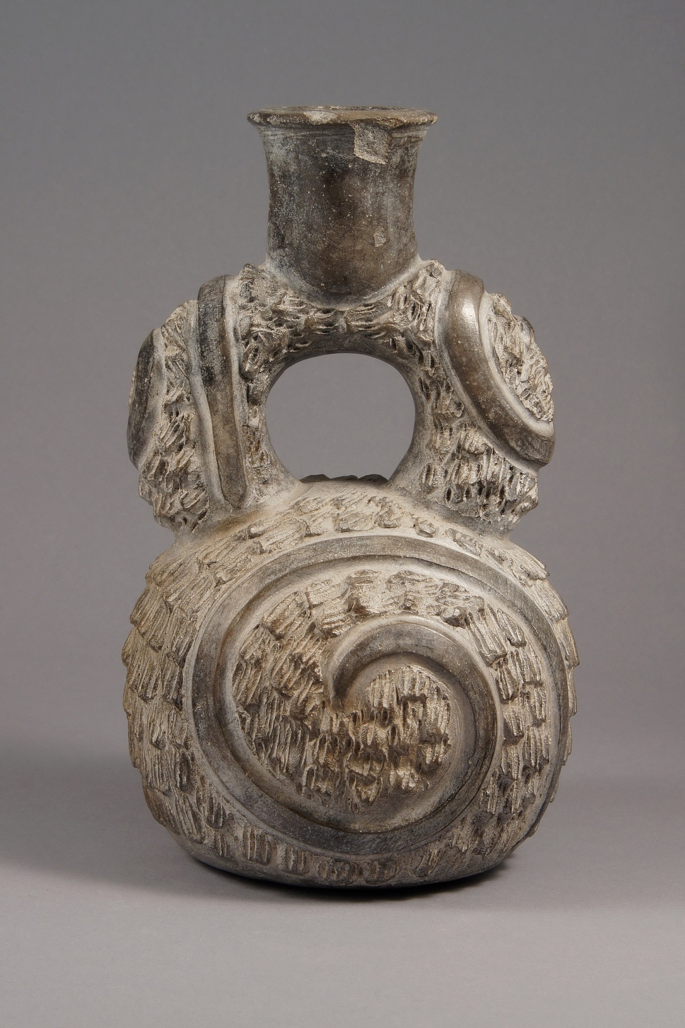 Peru, Chavin Stirrup Spout Vessel
This is an early and characteristic vessel from Cupisnique in the north coast of Peru, including the spiral design and comb texturing.  A similar one is illustated in Donnan, "Ceramics of Ancient Peru" (1992: 29).
Media: Ceramic
Dimensions: Height 9"
Price Upon Request
M5044