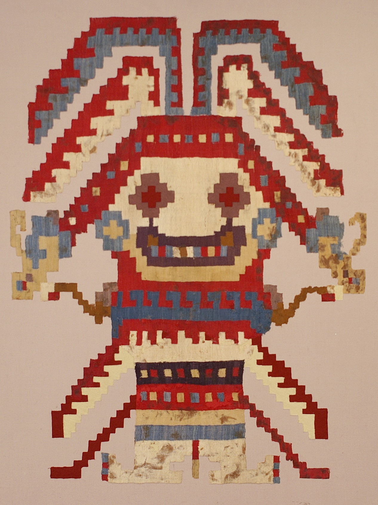 Peru, Huarmey Tapestry deity with rayed headdress
This is a very large single figure for any Peruvian weaving, and it was originally attached to a mantle of sheer cotton. The figure wears a headdress, ear spools, necklace, and tunic with a serpent belt in the red, blue and ivory colors typical of Huarmey textiles. The Huarmey Valley is the most southern in the Moche area and had, therefore, a lot of Wari influence in its art. This figure is stylistically more Wari than Moche in its abstract appearance.
Media: Textile
Dimensions: Length 32" x Width 24"
Price Upon Request
92305