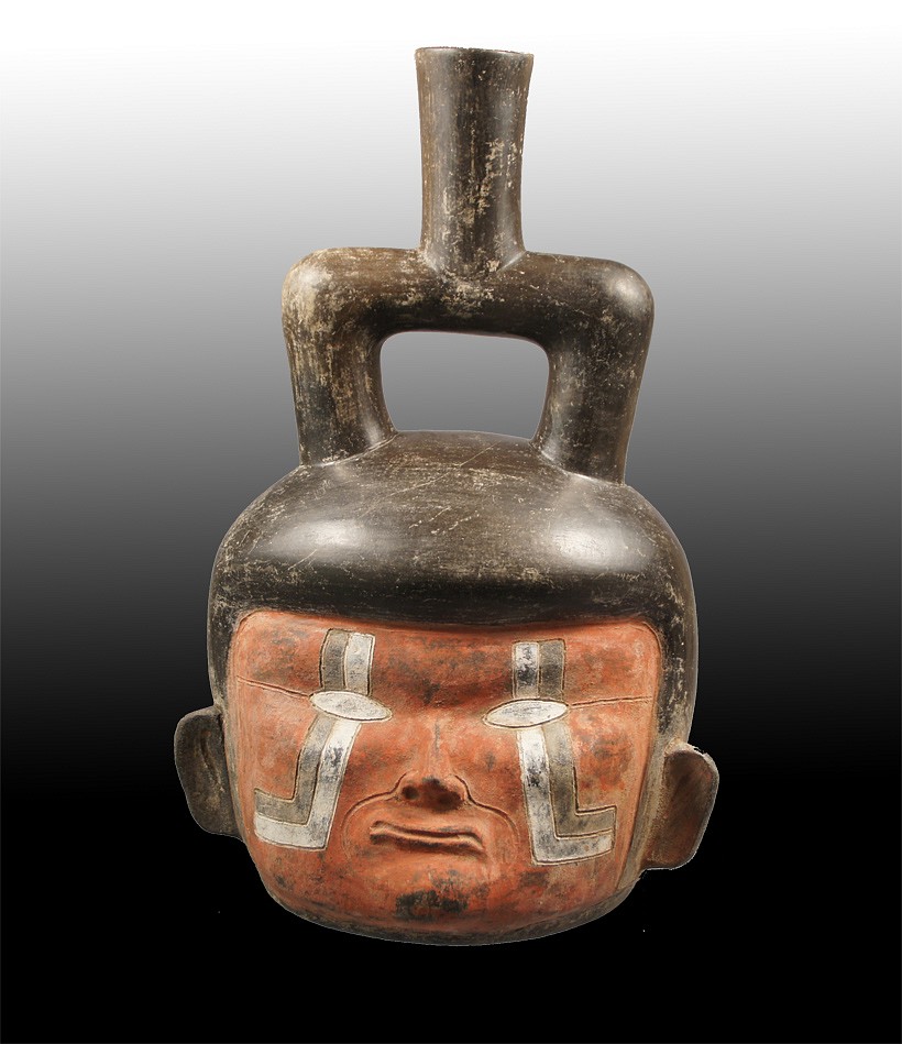 Peru, Chavin Stirrup Spout Portrait Vessel with Red Face and White Tears
There are few published,  authenticated, Chavin ceramic portrait heads and this is the only known one of its kind with post -fire red and white pigment.  The face has an unusually sensitive expression and delicately incised black and white tears that radiate outwards.  There is a similar Chavin portrait vessel in the Linden Museum- Stuttgardt.  Another Chavin portrait in the Larco collection and illustrated in THE SPIRIT OF ANCIENT PERU (pg.81) also has similar facial features:  small ears, slanted eyes, small nose and thin lips - but in addition also has wrinkles.  Author Richard Burger identifies this portrait as an elderly person. It is possible that the red-faced portrait is also a depiction of the same person that the Cupisnique people may have revered.
Media: Ceramic
Dimensions: Height 12 3/8" x  Width 8"
Price Upon Request
n2108