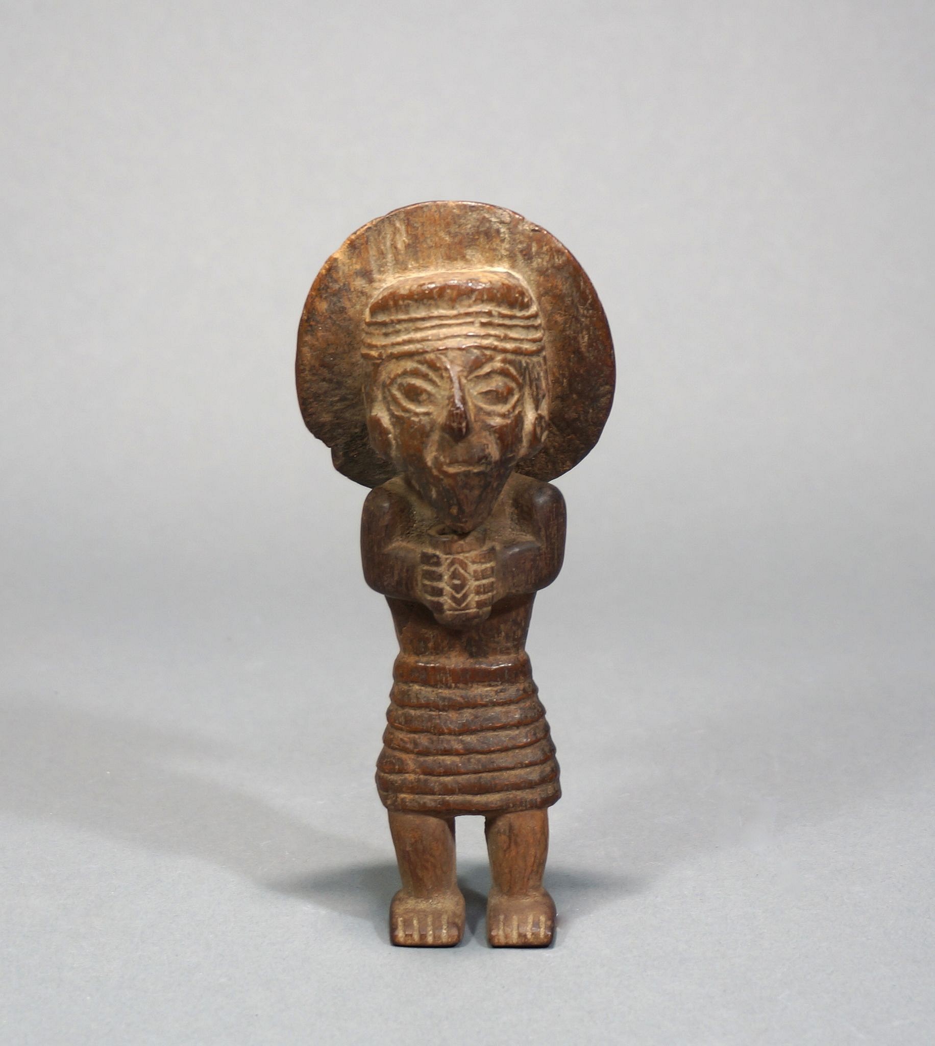 Peru, Wooden Man
Effigy figure of a high status individual wearing an unusual circular feather head dress and holding a kero.  The shirt is also unusual, with a multi-layered construction.
Media: Wood
Dimensions: h: 5 3/4"
Price Upon Request
n4004
