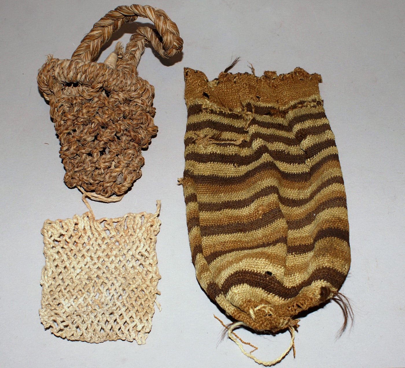 Chile, Three Types of Bags used by Fisherman
The bag with the handle is made of hemp, and would have been used for storing tools.  The white cotton bag was used to store bait for small fish.  The striped bag was made of wool with a draw string on top and a mesh on the bottom.  This bag would have been used for holding small fish.   Each bag was made with a different weaving technique.
Media: Textile
Dimensions: Lengths vary:  3"-8"
n6045