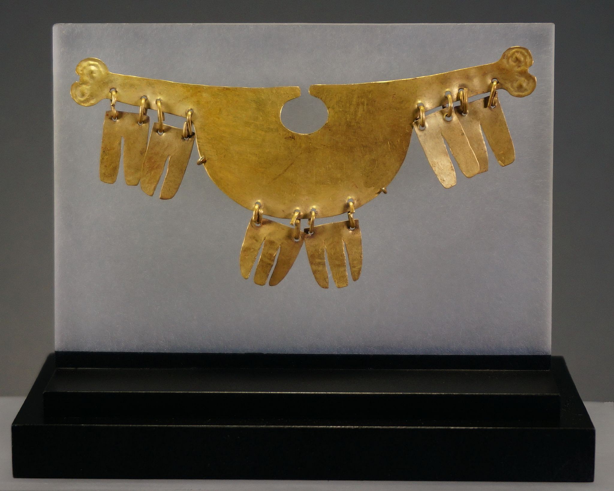 Peru, Salinar-Early Moche Gold Nose Ornament With Dangles in the Form of Bird Feathers
Unusual and rare nose ornament from the Salinar culture with stylized bird heads at each end and six dangles imitating feathers. A similar example is illustrated in "Oro del antiguo Peru" by JosÃ© de Lavalle (1992: pl. 94).
Media: Metal
Dimensions: Width 4" x Height 1 3/4"
Price Upon Request
96164