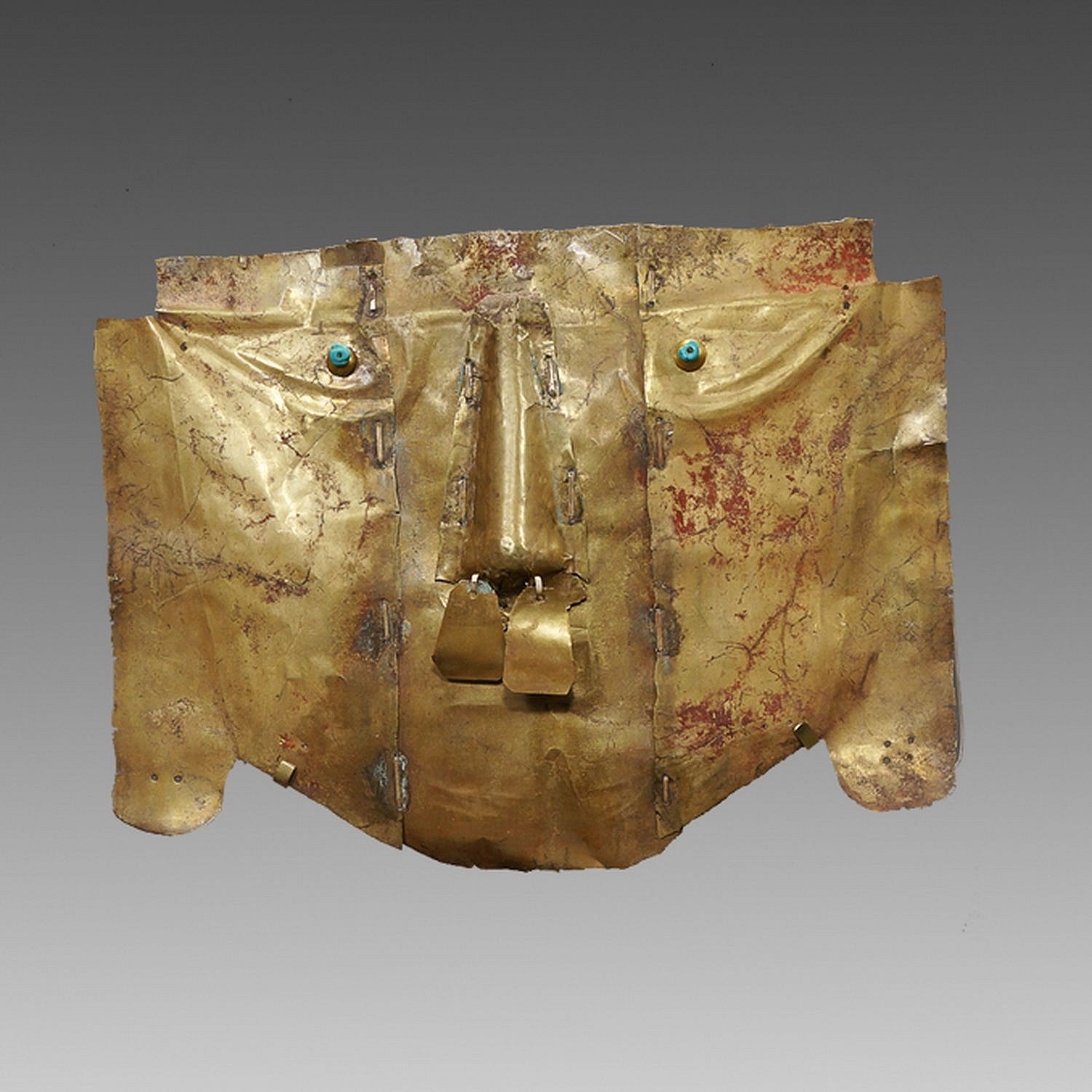Peru, Sican Gold Mask of the Third Type
A classic type of mask from the 3rd Phase, constructed in 3 parts and held together by ancient gold staples.  The eyes have turquoise bead pupils with gold hemispheres.  Traces of the original cinnabar remain.  Sicán masks are discussed in THE ART OF PRECOLUMBIAN GOLD - The Jan Mitchell Collection, page 66 - see example(s).  The Sicán culture was extremely wealthy and was known to have built the largest city in the Americas, Chan- Chan, outside of the modern city of Trujillo.  The Sicán were excellent gold workers, and when the Incas conquered them, they brought the metalsmiths to the Inca capital of Cuzco.  Similar masks are illustrated in THE GOLD OF PERU-MUJICA GAILLO Collection. Ex. Private New York Collector.
Media: Metal
Dimensions: Height: 7.75" x Width 10 1/8"
&bull;SOLD
n4001