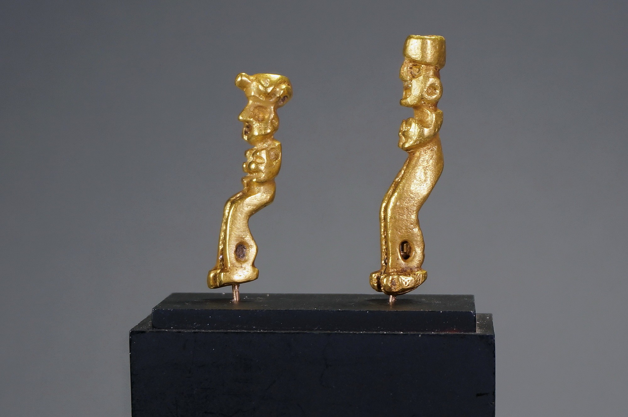 Peru, Two Inca Miniature Cast Gold Standing Figures
These two solid cast gold figures are highly unusual subjects.  Each figure has exaggerated hands and elongated legs.  Both figures have cast suspension holes above the ankles.  The top of each figure has a hollow shape that could have been used to insert feathers.  The only other example illustrated is in Oro del Antiguo Peru, lamina 210 (7 cm or 2.75").  One figure is wearing a headdress with a feline motif and the other one with a simple cylindrical shape.  Ex. New York collector, prior to 1970.
Media: Metal
Dimensions: Height:1.5" and 1.75"; Weight: 24 grams for pair.
$6,500
n7028