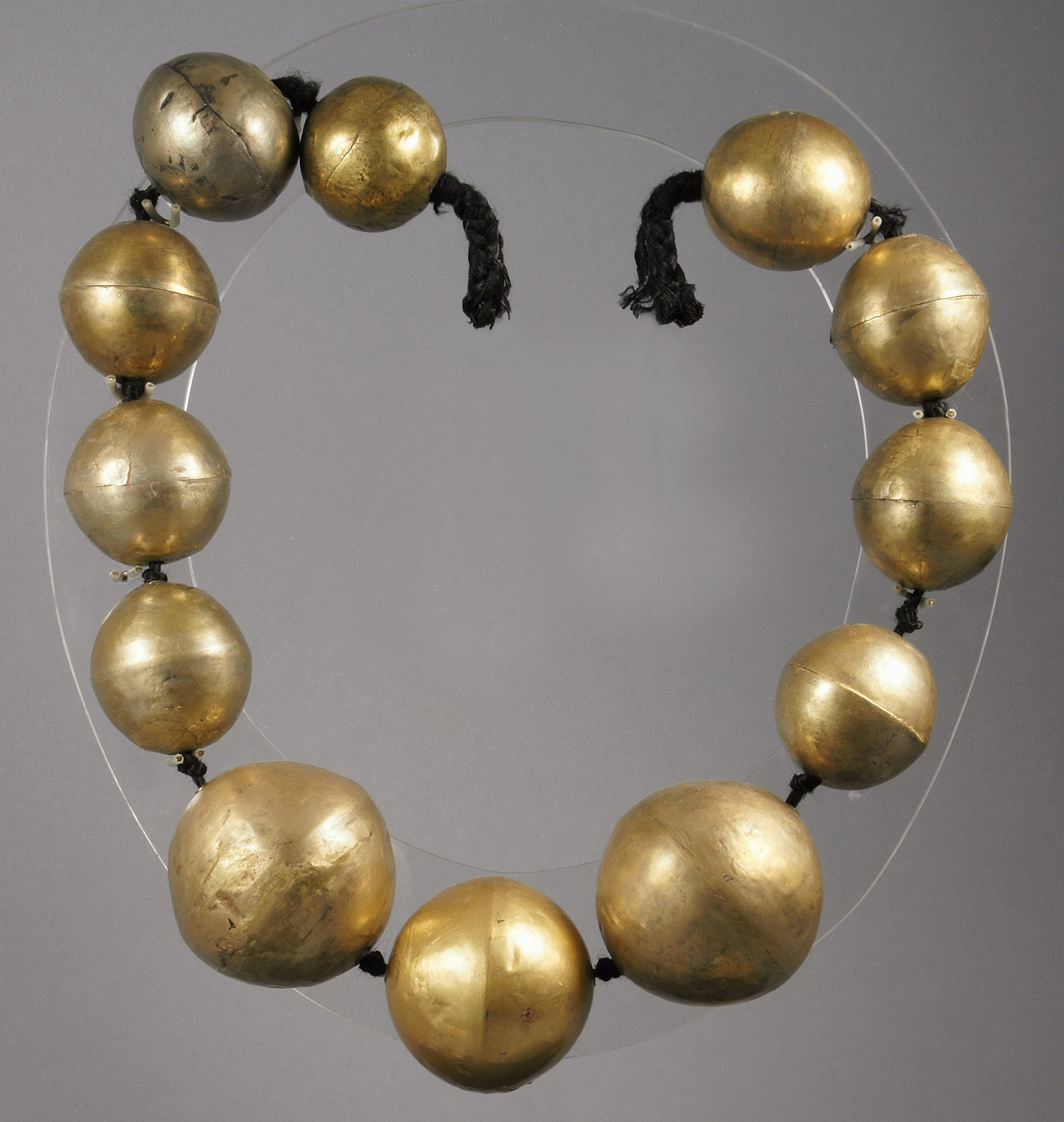 Peru, Chimú Gold 29" Necklace of Large Hollow Beads
The Chimú inherited a taste for hollow gold bead necklaces from their Moche predecessors. In both cultures, each bead was cast and hammered in two halves that were then joined together by soldering. In the Chimú technique, the edges of the two halves were nested together.  These beads are extremely light with a greater percentage of silver than gold.  They used depletion gilding to bring the gold to the surface by using of heats and salts.    This allowed the Chimu to make the gold available for a large and growing ruling class. Private Florida collection prior to 1980.
Media: Metal
Dimensions: Necklace Length: 29"; largest bead 2 1/4" diameter - smallest 1 1/2"
$21,000
M7991