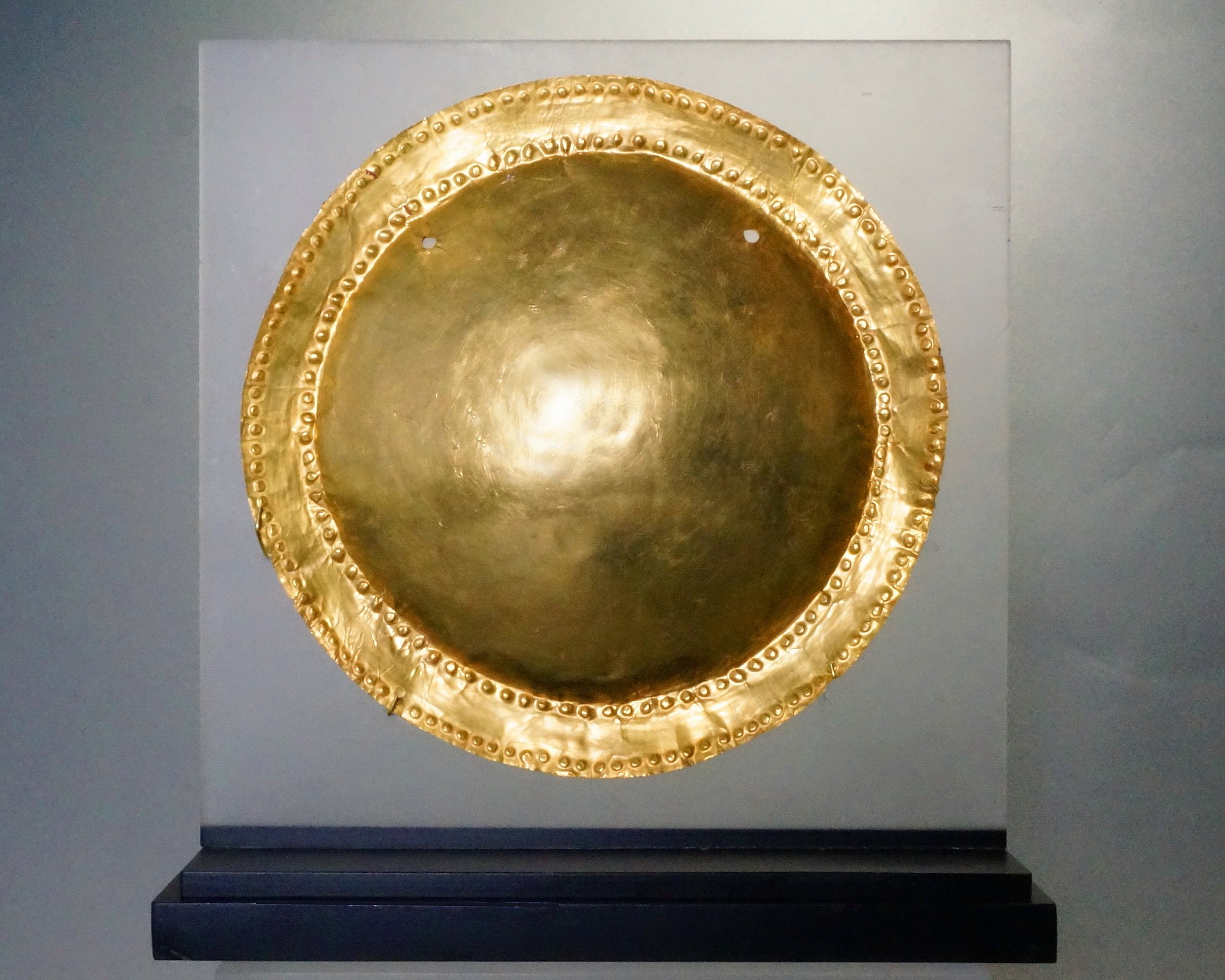 Panama, Macaracas (Cocle) Circular Gold Disc With Concave Center
The disc is embellished with two bands of small bosses on the narrow rim.  There is a pair of suspension holes.   On Columbus’ 4th voyage off the coast of Panama, he and his men saw Indians wearing "Mirrors of gold." Illustrated in THE ART OF PRECOLUMBIAN GOLD, p. 119. Ex New York collector, prior to 1970.
Media: Metal
Dimensions: Diameter 5 3/8"     24.6 Weight: grams
&bull;SOLD
n7058