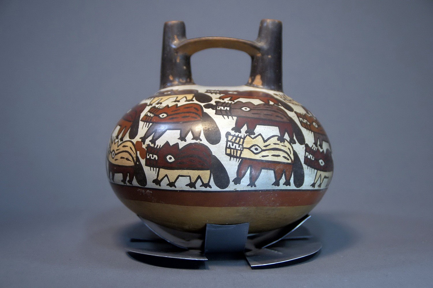 Peru, Nasca Bridgespout Vessel Painted with 23 Foxes On White Ground
A late Nasca period vessel, T/L tested, verified as 1650 years old by CIRAM Labs.  Prof. Donald Proulx in his Sourcebook of Nasca Ceramic Iconography (pg. 141) describes the Andean Fox with the following characteristics, drawn in profile with elongated snout, pointed ears, whiskers and thick black tail. Deiter Eislab Illustrated 5 ceramics with similar painted foxes in ALTPERUANISCHE KULTUREN NAZCAII, plate 6-9.
Media: Ceramic
Dimensions: Height; 5 1/2" x  Diameter: 6"
Price Upon Request
n4052