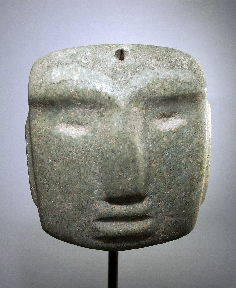 Mexico, Chontal Green Stone Mask with eyebrows
Classic Chontal style mask with unusual depiction of the eyebrows, which are etched into the stone.  Similar masks are illustrated in CHONTAL: ANCIENT STONE SCULPTURE FROM GUERRERO MEXICO, page 59, A, B, C. & page 60.  There are strong root marks all over.
Media: Stone
Dimensions: Width: 6 1/4" x Height 7"
$12,000
N5021