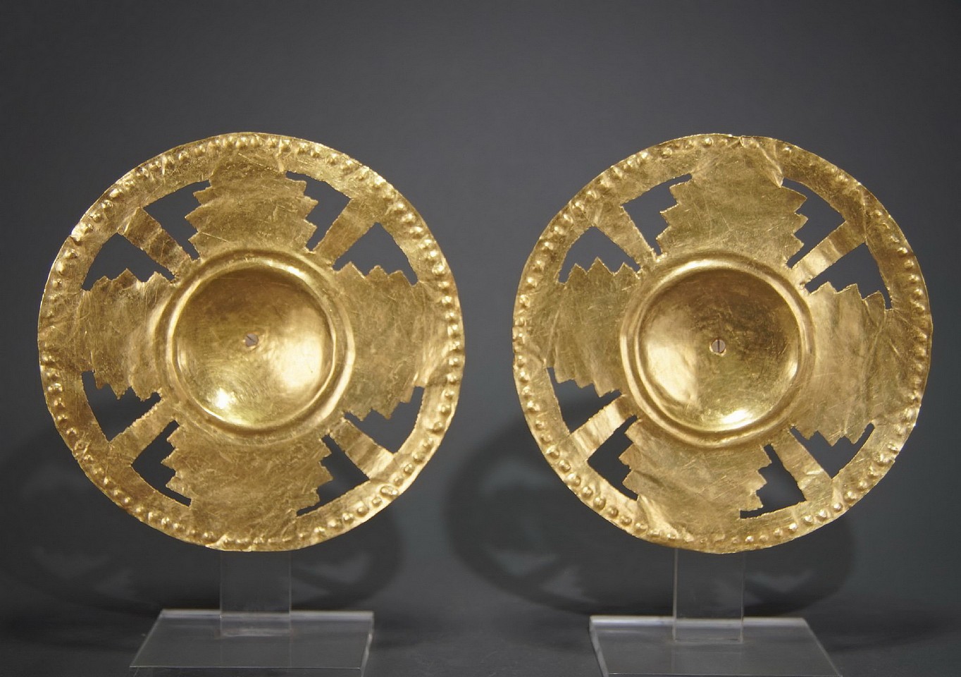 Colombia, Pair of Sinu Gold Ear Ornaments with Cutout Step Design
Around the outer rim is an embossed design.  Each ornament is almost the same size and weight.  Ex-Jan Mitchell collection, prior to 1970.
Period: Colombia, Sinu, Cauca River Valley, c. AD 1000 - 1500
Media: Metal
Dimensions: Diameter 5" each. Weight: 40.7grams & 40.4 grams.
Price Upon Request
P1004