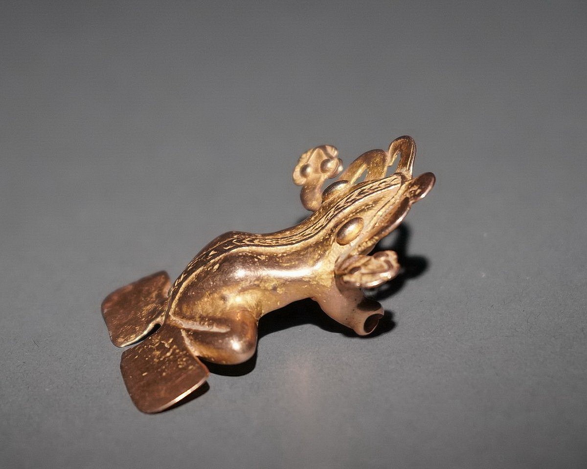 Panama, Classic Veraguuas Cast Gold Frog with Serpents
This beautiful cast gold frog has  large spherical eyes and a ribbon down its back and bordering its flippers.  There is a modern suspension loop hung from the original suspension arrangement.  Jan Mitchell collection, prior to 1970, by descent to his sons.
Media: Metal
Dimensions: Length: 2 7/8" x Width: 1 3/4"  Weight: 32.4 grams.
$6,450
p1045a