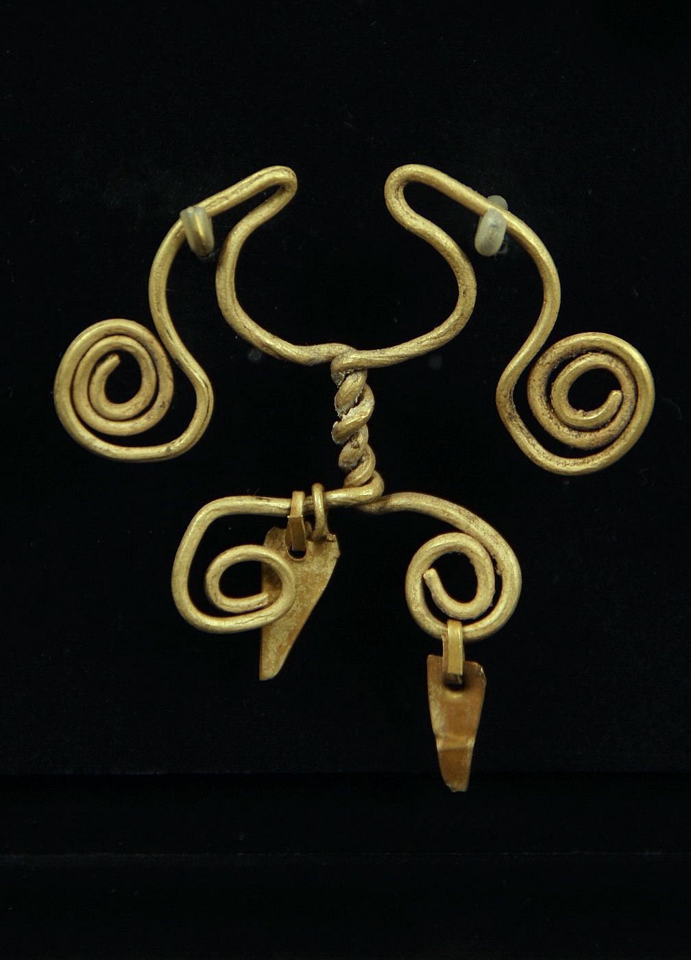 Peru, Chavin Gold Spiral Nose Ring with Two Twisted Wires and Two Dangles
This wire nose ring was made of one hammered sheet of gold, folded on itself, and cut.   The ornament was hammered and coiled with the original suspended dangles.

Media: Metal
Dimensions: Height:1 1/4"   Weight: 4.8 grams
$2,100
94222