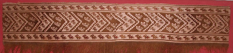 Peru, Chancay Fringed Tapestry Border with Cats and Birds
This was likely the border of a tunic and was made as two loom widths sewn together with an additional fringe sewn horizontally.  The design of cats and birds alternating in angled bands is bordered above and below with rows of additional small birds. It is unusual to see such red and gold highlights dyed on cotton.
Media: Textile
Dimensions: Width: 37" Height: 9"
$2,200
94277