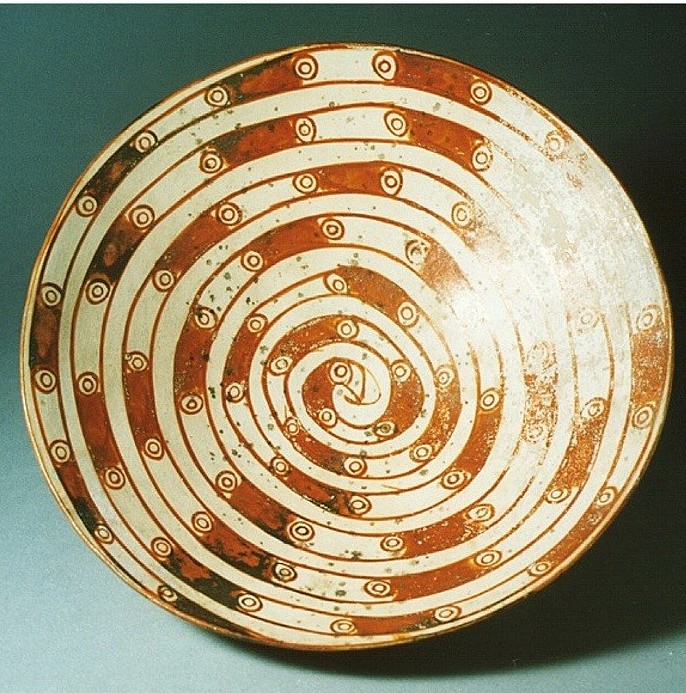 Peru, Cajamarca Low Orangeware Bowls with Coiled Serpent
This bowl has an orange and white spotted coiled serpent motif and a footed base.  The Cajamarca culture has a long role in Peruvian pre-history going back to Chavin times until 1532 when the Inca king Atahualpa was killed by Pizarro.  Today there still exists a beautiful cut stone "Inca Bath" of warm mineral water that was enjoyed by Inca nobility.  A similar style of ancient plate from Cajamarca is in the Museum at Cajamarca.  The orange and white slip decoration demonstrates the high artistic control that the Cajamarca artisans had over the medium.  A great deal of control over the firing process was required to prevent the orange slip from turning brown
Media: Ceramic
Dimensions: Diameter: 10 inches.
$2,500
97111a