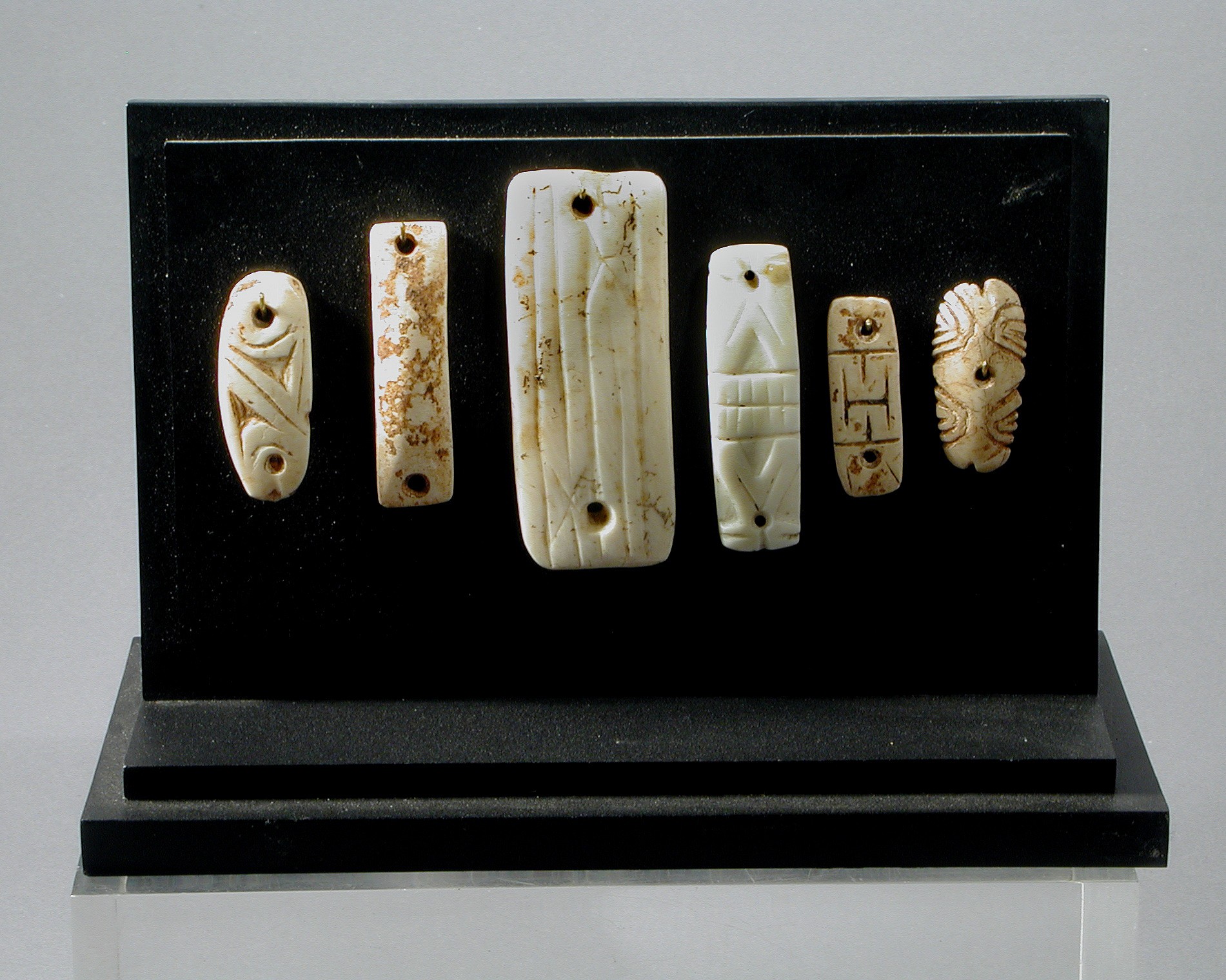 Dominican Republic, Six Taino Bone and Shell Bracelet Elements
These ornaments have two drilled holes at either end.  They were used as either bracelet elements or necklace clasps.  It is hard to find shell ornaments with such good patina still intact.
Media: Shell
Dimensions: From left: 1 1/4, 1 3/4", 2.5", 1.5", 1 1/4", 1"
$2,400
98372B