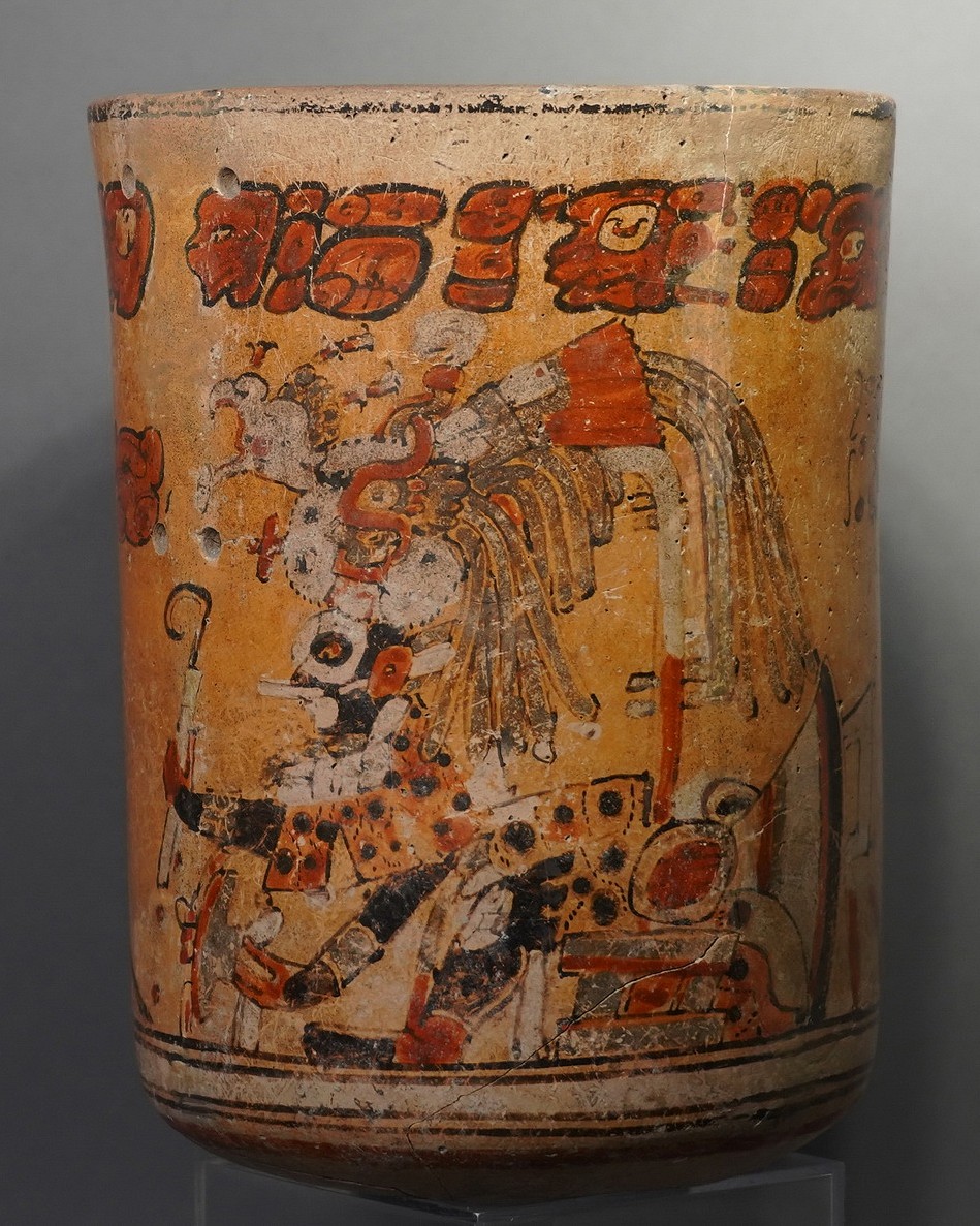 Guatemala, Mayan Polychrome Ceramic Cylinder Vessel with Ruler and Otherworld Serpent Deity
This compelling Mayan painted cylinder depicts a ruler, or cacique, enthroned in the jaws of the Serpent Deity from the otherworld. The top register of the vessel contains the Primary Standard Sequence - a sequence of characters identified by scholar Michael Coe in The Maya Scribe and His World in 1973.  These glyphs are repeated in a similar formation on many vessels and are thought to be associated with Mayan myth and ritual.  The Mayans believed that human souls were required as a sacrifice to propel the eternal wheel of cosmic order, and that the sacrificed souls would live beyond the death of the body.  Fierce anthropomorphized serpent figures, such as the one depicted here, were employed by the Mayans to represent the archetypal forces of death and sacrifice.
Scholar Justin Kerr (mayavase.com) lists this cylinder as being affiliated with the term Och Chan Yopat, which means "the storm god enters the sky."  This phrase is also found on a Mayan frieze that in Guatamala, described by Rachel Newer in The Smithsonian Magazine on August 9, 2013.  This phrase describes the terrible, formidable nature of the cacique as well as the serpent god.  The vase is painted in broad, sweeping lines of motion, using vibrant red blocks and aggressive black lines that weave in and out and morph from curving to linear. Acquired in Tokyo, Japan, prior to 1970.
Kerr database #K937 (mayavase.com).
Media: Ceramic
Dimensions: Height: 7 7/8" x Diameter: 5 3/4"
$8,500
N5022