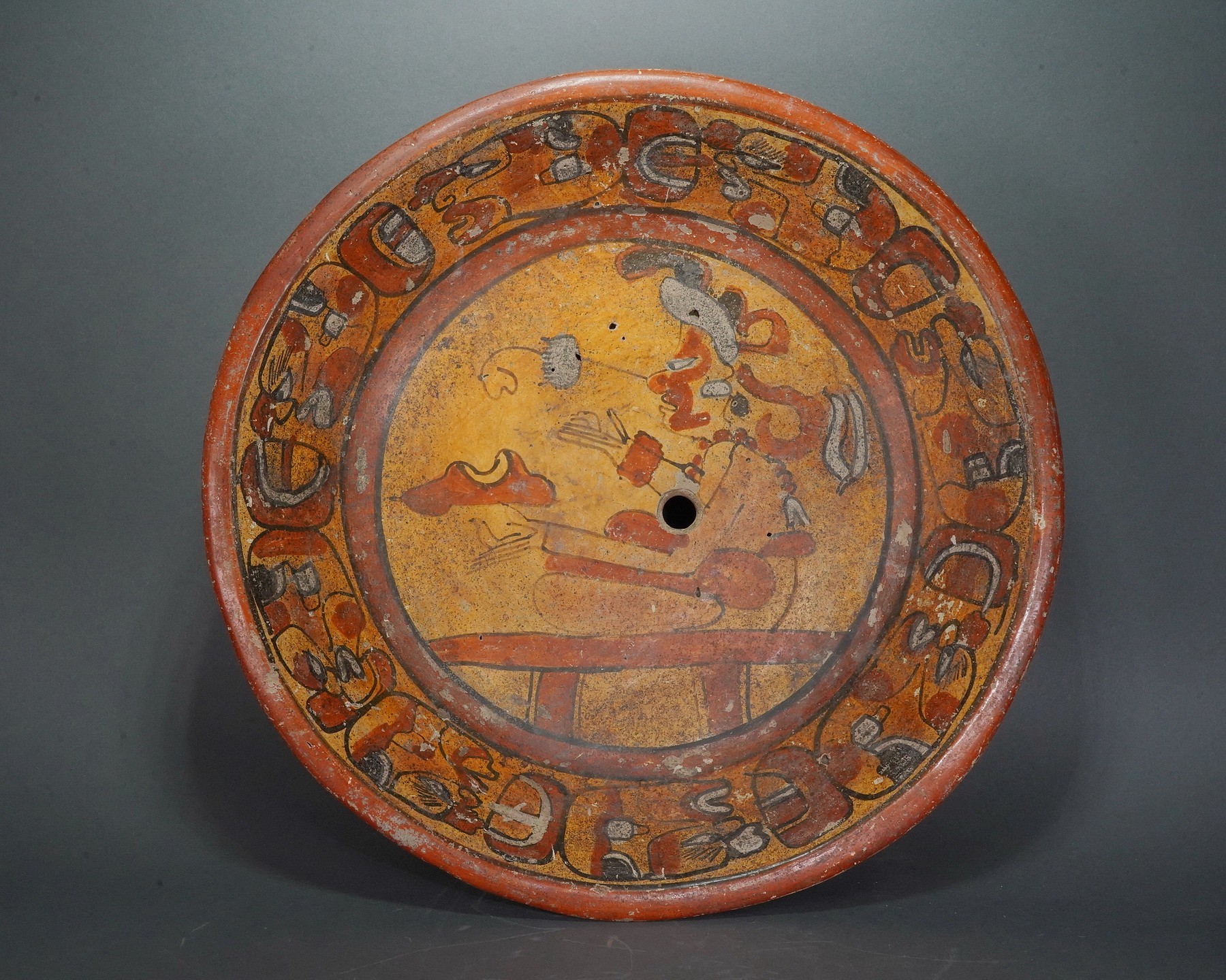 Guatemala, Mayan Tripod Dish with Seated Figure
This painted Mayan tripod dish features eight repeating  glyphs of deity heads in profile painted around the inside  edge.  The central seated figure is likelay shaman.  He is  holding two birds, which represent communication.   There is a "kill hole" in the center of the dish.  The back of the dish is painted with scallop design.  Formelry in the collection of Hiroshi Muira, Tokyo, Japan, prior to 1980.
Media: Ceramic
Dimensions: Diameter: 11" X Height: 3 1/2"
$3,750
n6012B