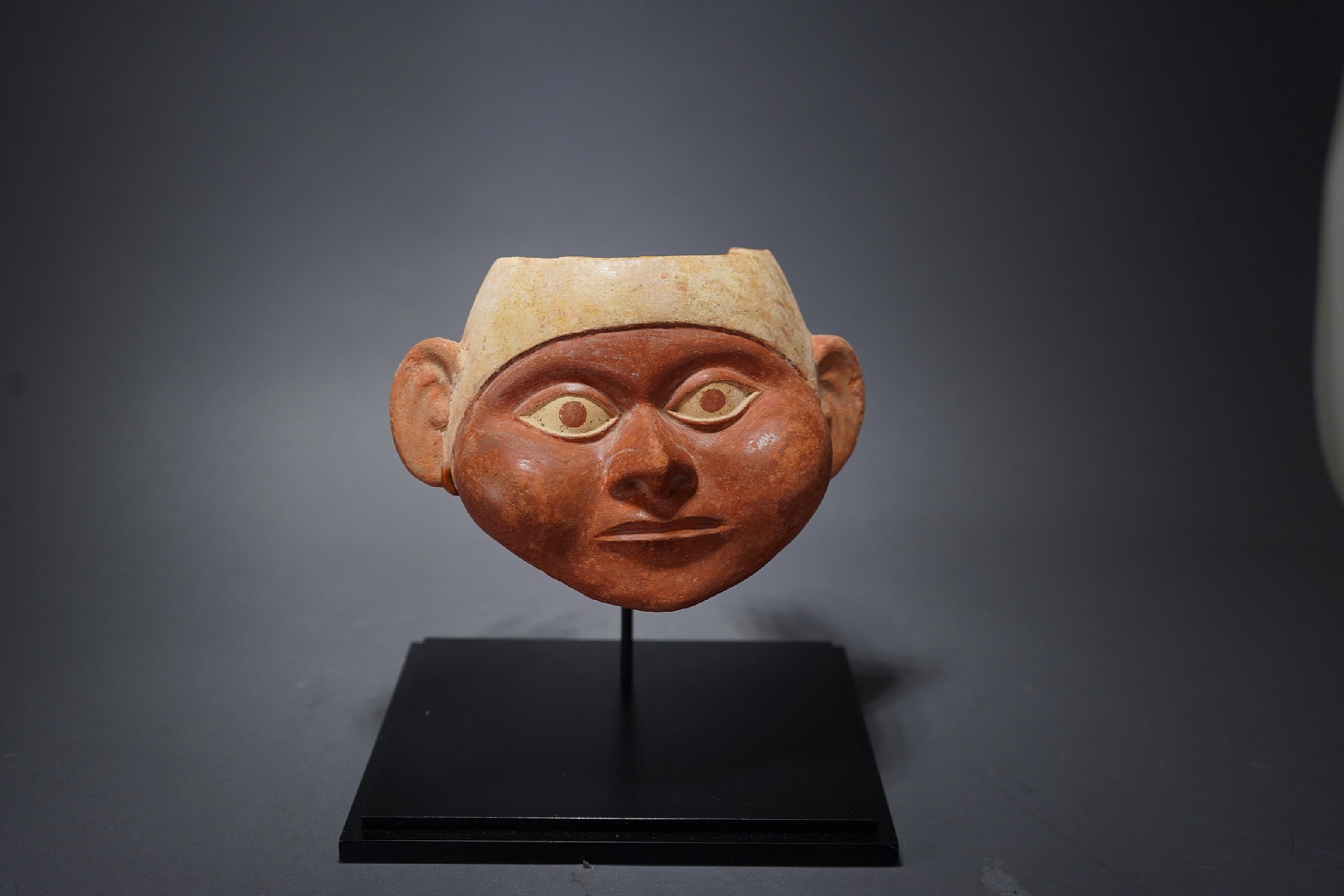 Peru, Moche Ceramic Section to a Portrait Vessel
The portrait masks of the represents the same individual that is illustrated in MOCHE PORTRAITS OF ANCIENT PERU by Christopher Donnan on page 92.  The published version has the exact same facial features, but is older in age.  The Moche are known to have made portraits of the same person throughout different life stages. Ex. collection of Mark Moore, by descent from his father Lee Moore.  Prior to 1970.
Media: Ceramic
Dimensions: Height: 5 1/2" x Width: 7 1/4"
Price Upon Request
p2045