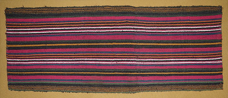 Chile, Pre-Inca Storage Bag from Arica, Chile 
This large striped bag is decorated with a series of thin and broad vertical stripes in brilliant hues of red, green, tan, brown and white. The weaving was opened along the vertical sewn sides and is in excellent condition indicating that it was woven for ritual tribute rather than used in everyday life. These long, narrow bags are referred to as talegas.  A group of talegas is catalogued in ARICA: 10,000 YEARS, ref # 195-199. Acquired in 1995 from Eduardo Aldunate, Santiago, Chile prior to the 1980s.
Weaving Technique: plain weave.
Professionally mounted on a stretcher.

Media: Textile
Dimensions: Length 29" x Width 13"
$5,800
95107