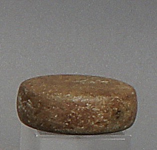 Dominican Republic, Pre-Taíno  Circular Polishing Tool
This rounded stone is polished on all surfaces.  One side has an incised "V"as if it were pointing to some place.
Period: Dominican Republic, Taíno , Neolithic, c. 1000 - 400 BC
Media: Stone
Dimensions: Diameter: 1 3/4" x Thickness: 1/2"
98198
