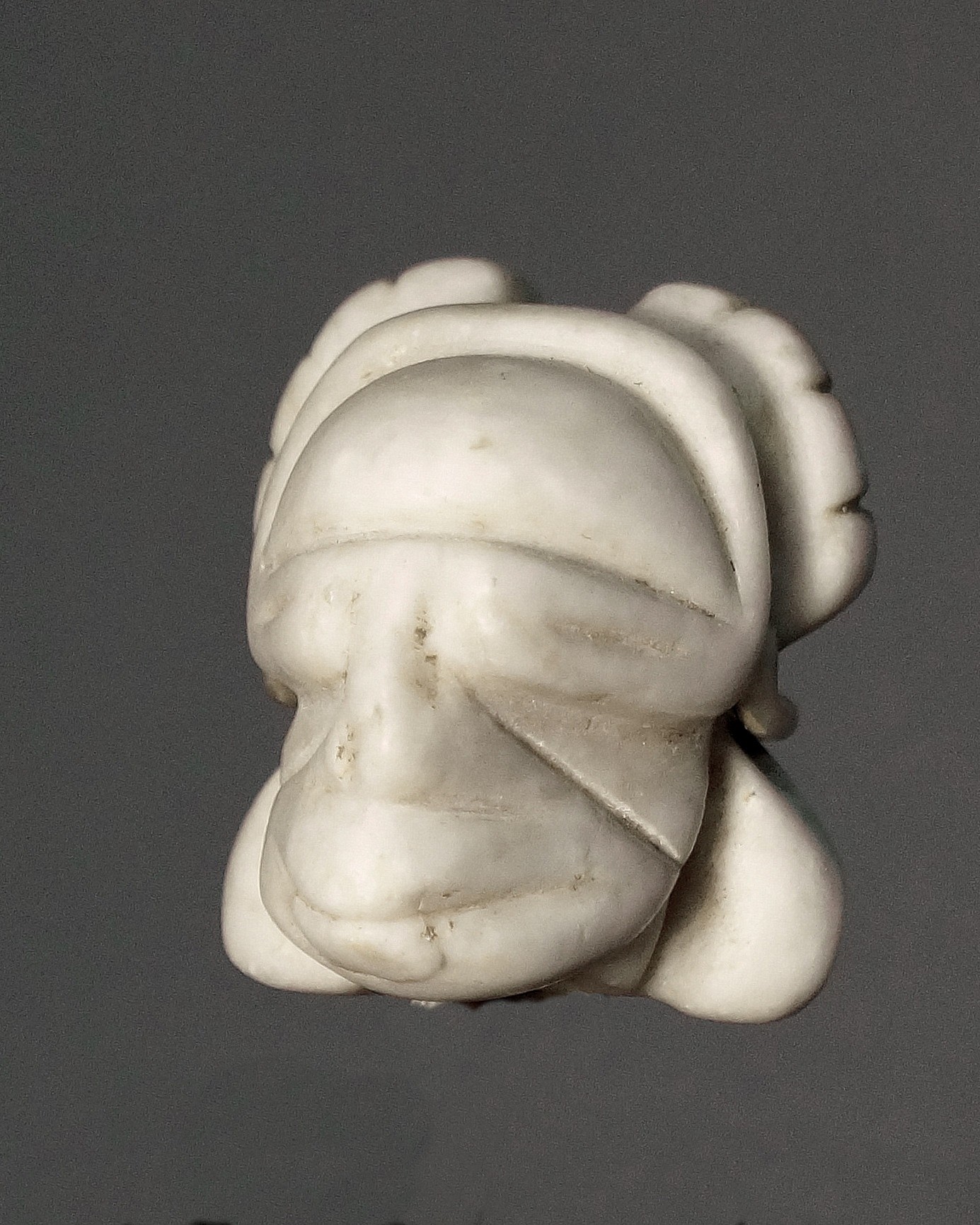 Dominican Republic, Taíno Carved White Marble Amulet of a Deity Head with Closed Eyes
This head was once a part of a larger figurine. Broken in ancient times just below the chin, the stone was re-carved and used as an amulet.
Period: Dominican Republic, Taíno , c. AD 1000 - 1500
Media: Stone
Dimensions: Height:  1 3/8"
98425