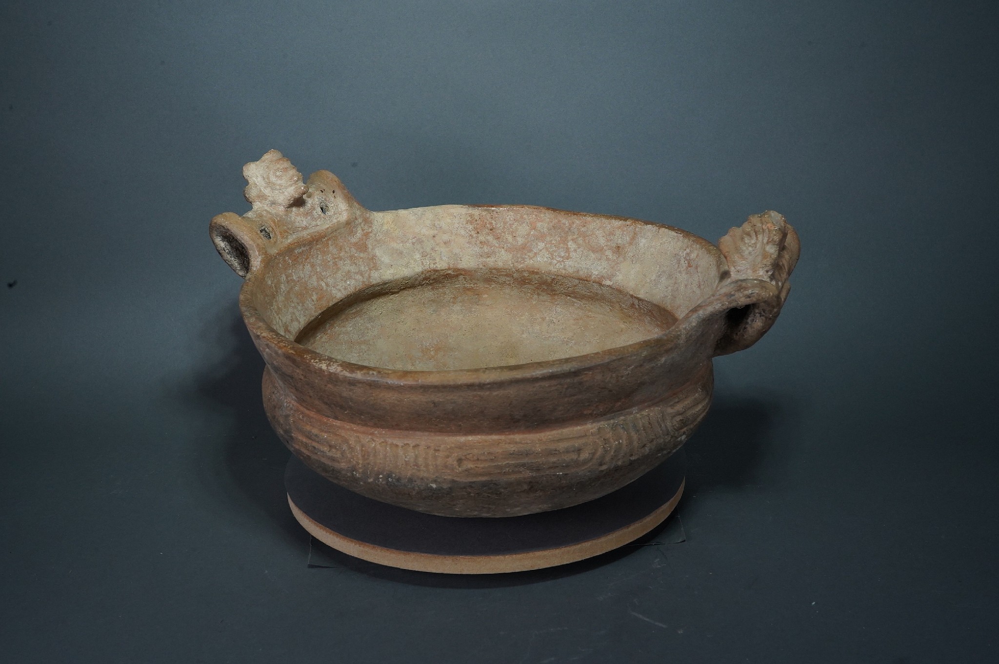 Dominican Republic, Pre-Taíno  (Igneri) Ceramic Bowl with Bat Shaped Handles
The Igneri were Arawak-Ostoinoid people who inhabited the Greater Antillies from the third through tenth centuries. Their ceramics can be identified by the bat shaped handles, broadly incised designs and tiered bases. The Ostionoid Igneri inhabited the zone around Altos de Chavon, and similar vessels are discussed and illustrated in Commemorative Catalog, 1992: 15 and 47.
Period: Dominican Republic, Ostionoid, c. AD 200 - 900
Media: Ceramic
Dimensions: Height: 5" x Width 8"
99160