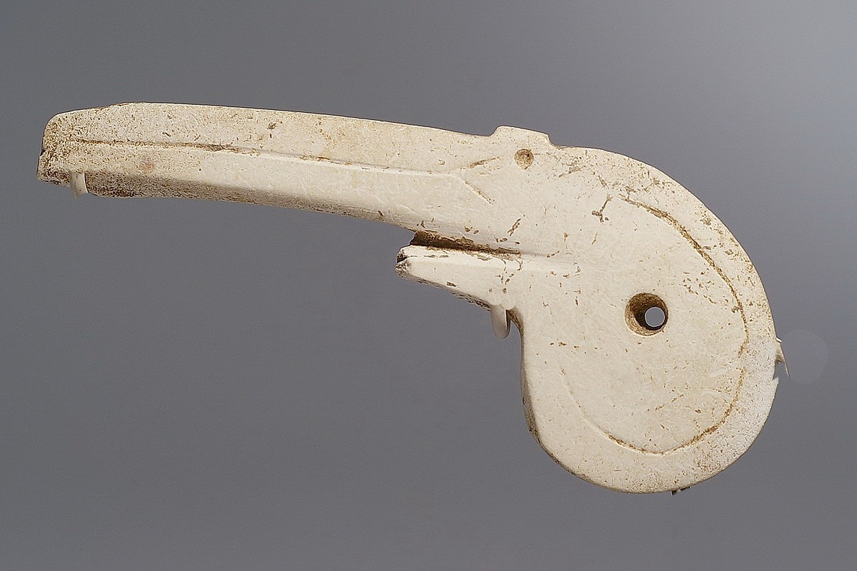 Dominican Republic, Taíno  Shell Amulet in the Form of a Pelican Head
This shell amulet is incised as a pelican head in profile, with the suspension hole in the center of the head naturally forming the eye. The shell used to create this amulet must have originally been quite in to provide a flat surface with a curve to form the pelicanâ€™s beak.
Period: Dominican Republic, Taíno , c. AD 1000 - 1500
Media: Shell
Dimensions: Length: 3 3/4"
99221