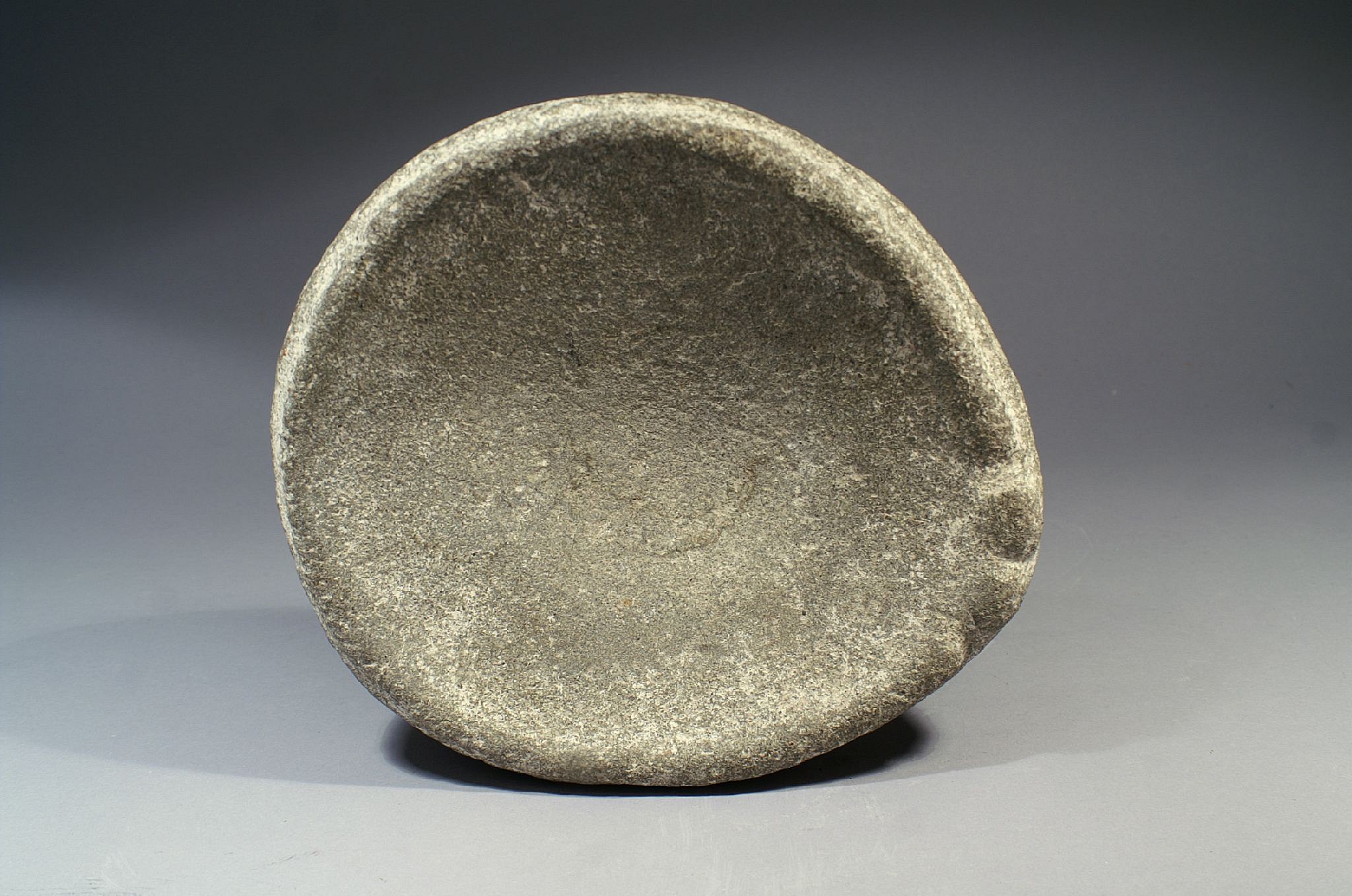 Dominican Republic, Taíno Stone Oval-shaped Mortar with Abstract Animal
This piece is unusual because of the embellishment of the rim design, perhaps representing a turtle, sacred to the ancient Taíno . It was likely used for ceremonial purposes; a more utilitarian object would have been plainer and exhibited more signs of wear.
Period: Dominican Republic, NeolithicTaíno , Casimiroid, Courian Subseries, c. 2660 BC - AD 240
Media: Stone
Dimensions: Diameter: 8.5" x Height: 3"
98121B