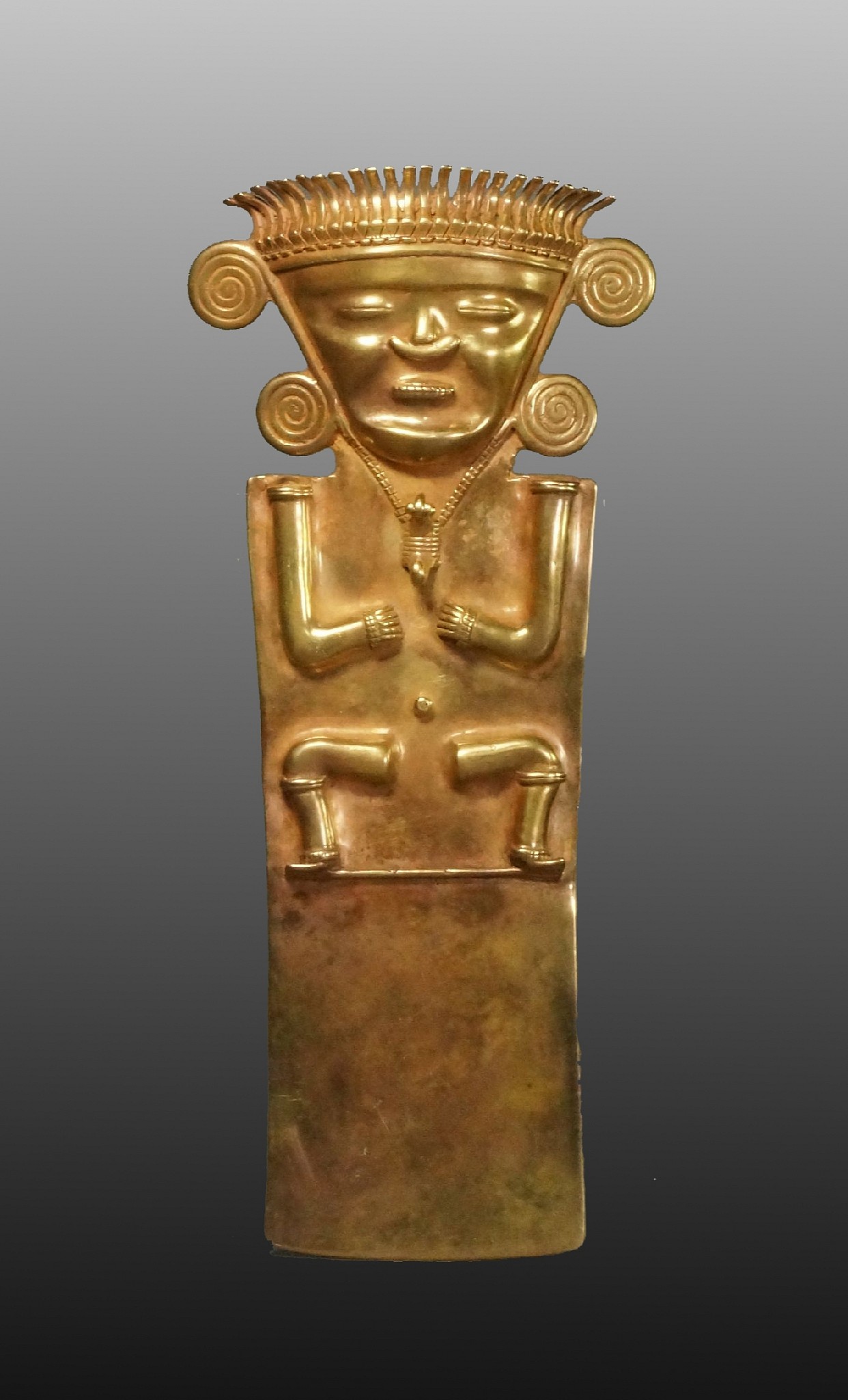Colombia, Quimbaya Cast Gold Pendant of a Male Shaman
This is the largest known gold Quimbaya shaman.  The shaman is in a state of trance or meditation, and wears elaborate ornaments, including: a crown with 24 birds facing downwards, a large pair of double-spiral ear ornaments, a crescent-shaped nose ornament, and a special gold necklace with a curly-tailed animal pendant.  There are two suspension loops on the back.  The casting is extremely well executed, with fine details on the crown and the necklace.  A similar ornament is in the Museo del Oro and only measures 7 1/2" in height. A pair is illustrated in The Dora Janssen Collection catalogue, which measures 7 1/2" in height.  Similar examples are also illustrated in MASTERWORKS OF PRE-COLUMBIAN GOLD: The Glassell Collections of The Museum of Fine Arts, Houston, p.151, and in The Art of Pre-Columbian Gold:The Jan Mitchell Collection, p.59.  Similar examples are also published in The Gold of Eldorado, by Warwick Bray, on p. 218.  From a Texas collector, acquired prior to the 1970s. Ex. Jan Mitchell collection, acquired prior to the 1980s by descent to his son David Mitchell.
Media: Metal
Dimensions: Height" 8 1/2"  x Width: 3 2/4"  Weight: 192 grams.
$165,000
n7061