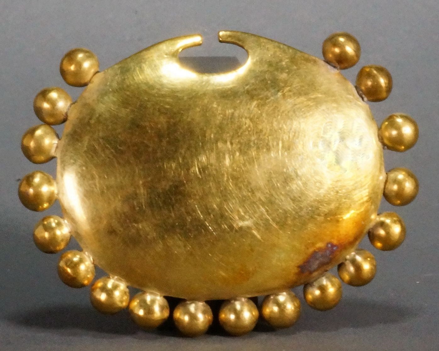 Peru, Moche Gold Nose Ornament Surrounded with 18 Spheres
Each of the spheres are individually soldered to the base.  Illustrated in Oro del Antiguo Peru, plate 134.  From a Texas collector, acquired prior to the 1970s.
Media: Metal
Dimensions: Height: 2 1/4" x Width: 2 3/4"     Weight: 27.3 grams.
$18,000
n8020